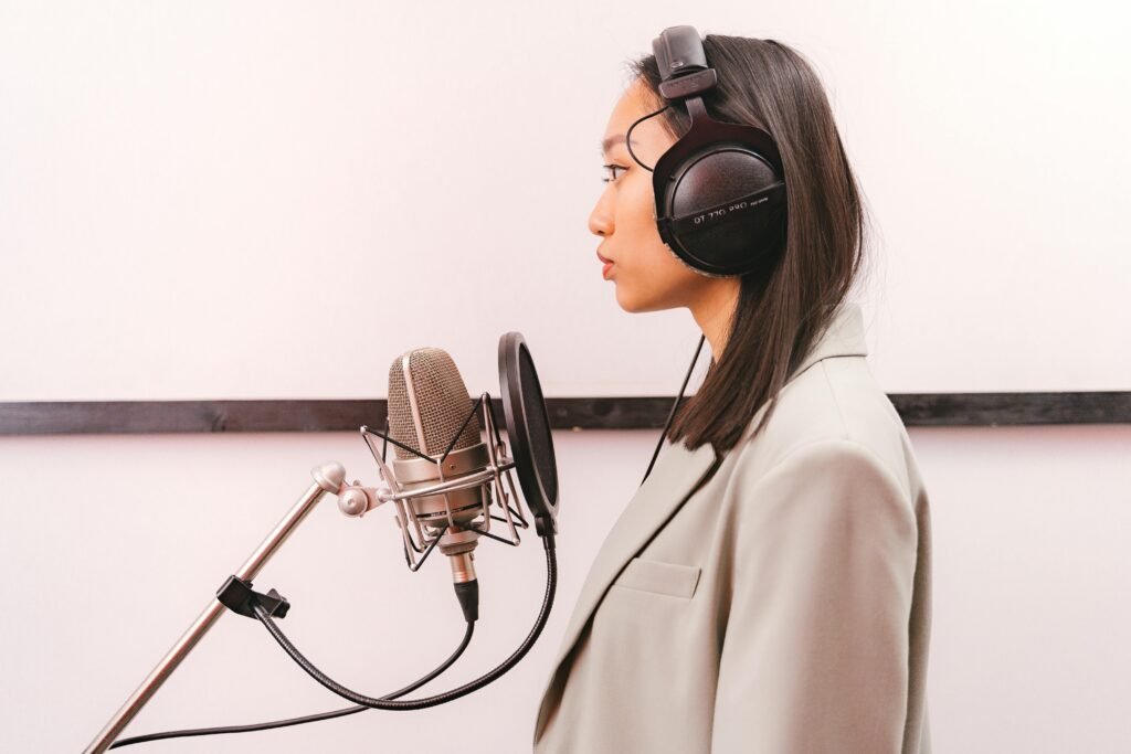 Professional wearing Audio-Technica ATH-M50xBT2 wireless headphones in a recording studio setup