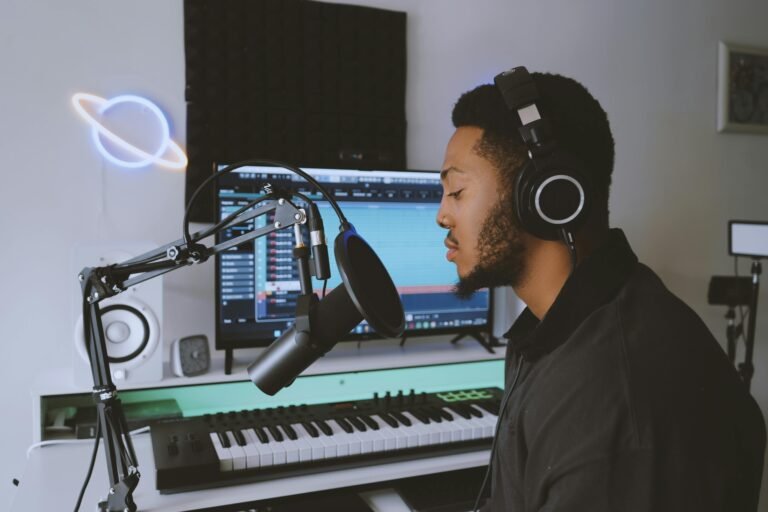 Person wearing Sony WH-1000XM5 wireless headphones while working at desk with laptop and smartphone