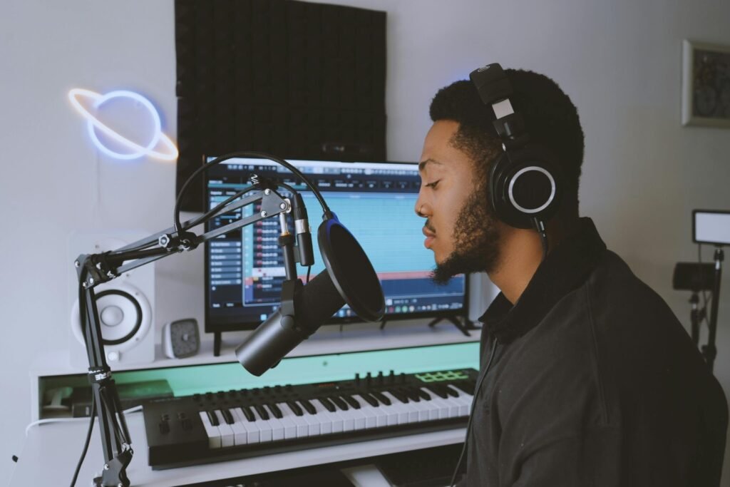 Person wearing Sony WH-1000XM5 wireless headphones while working at desk with laptop and smartphone