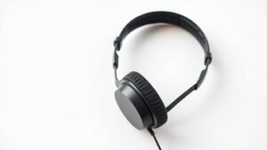 Professional studio headphones isolated on clean white background with soft side lighting highlighting the driver housing and cable connection in modern minimal product photography style horizontal composition