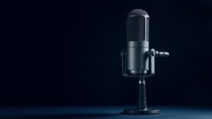 Professional condenser microphone on clean studio background. Large diaphragm microphone with shock mount positioned at slight angle. Soft diffused lighting from left side creating gentle shadows. Deep navy background. Modern minimal product photography style. Photorealistic detail showing capsule and body construction.