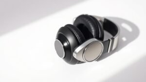 Professional gaming headphones photographed on clean off-white studio background with soft side lighting. Modern black and silver design with visible drivers and adjustable headband. Sharp focus product photography in horizontal format.