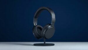 A single sleek wireless gaming headset resting upright on a minimal stand against a deep navy background. The headset features a bold over-ear design with subtle RGB accent lighting along the earcups and headband. Soft directional side lighting casts gentle shadows that emphasize the contoured curves and premium matte finish. Clean, modern studio atmosphere with no distractions.